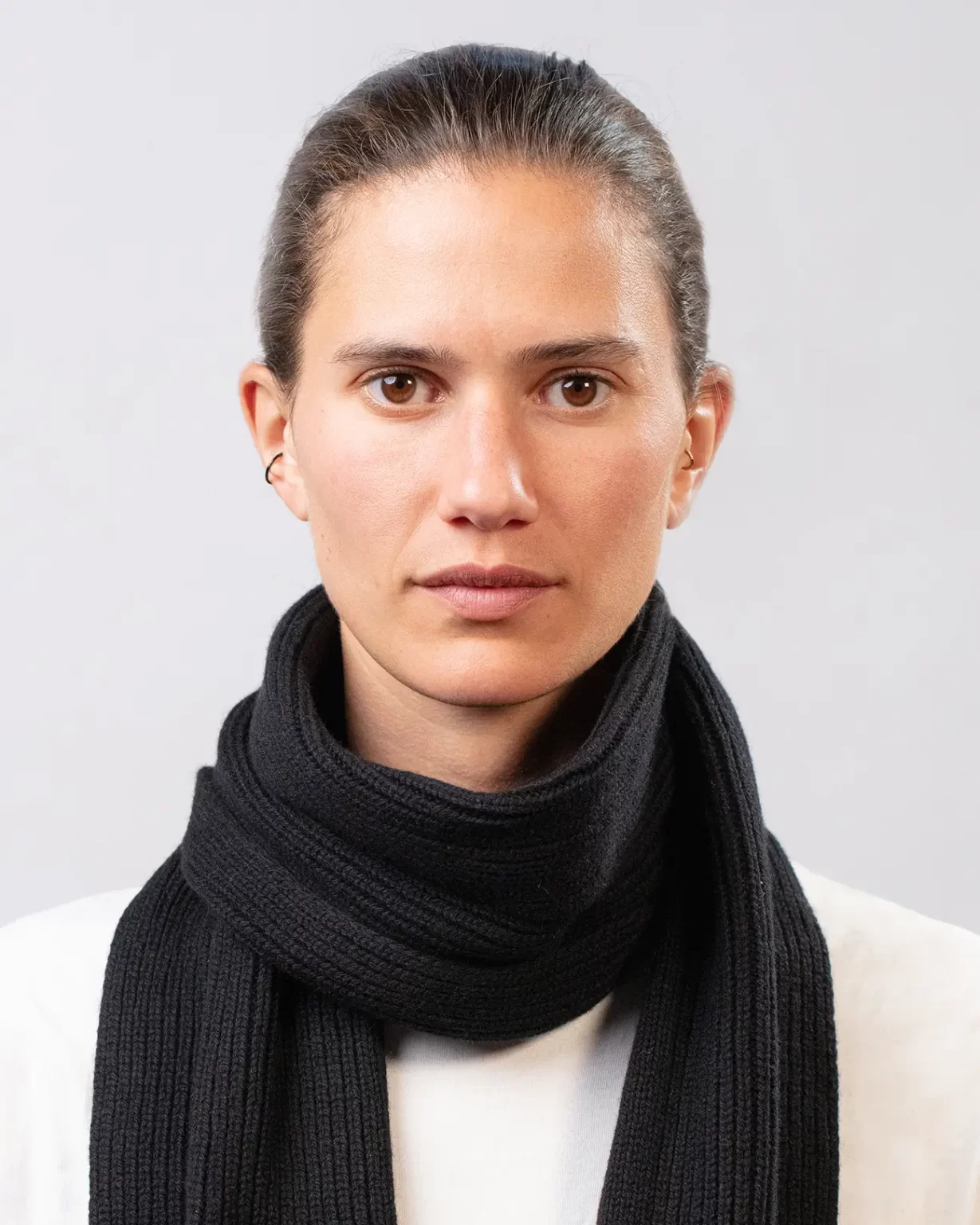 Photographie studio détaillée de l'Echarpe Cachemire Régénéré Noir, porté par un mannequin Femme. Cette écharpe est fabriqué en France, à partir de Laine et de Cachemire Recyclé, par la marque haut-de-gamme Maison Douillet. Cest un modèle pour Homme et Femme.