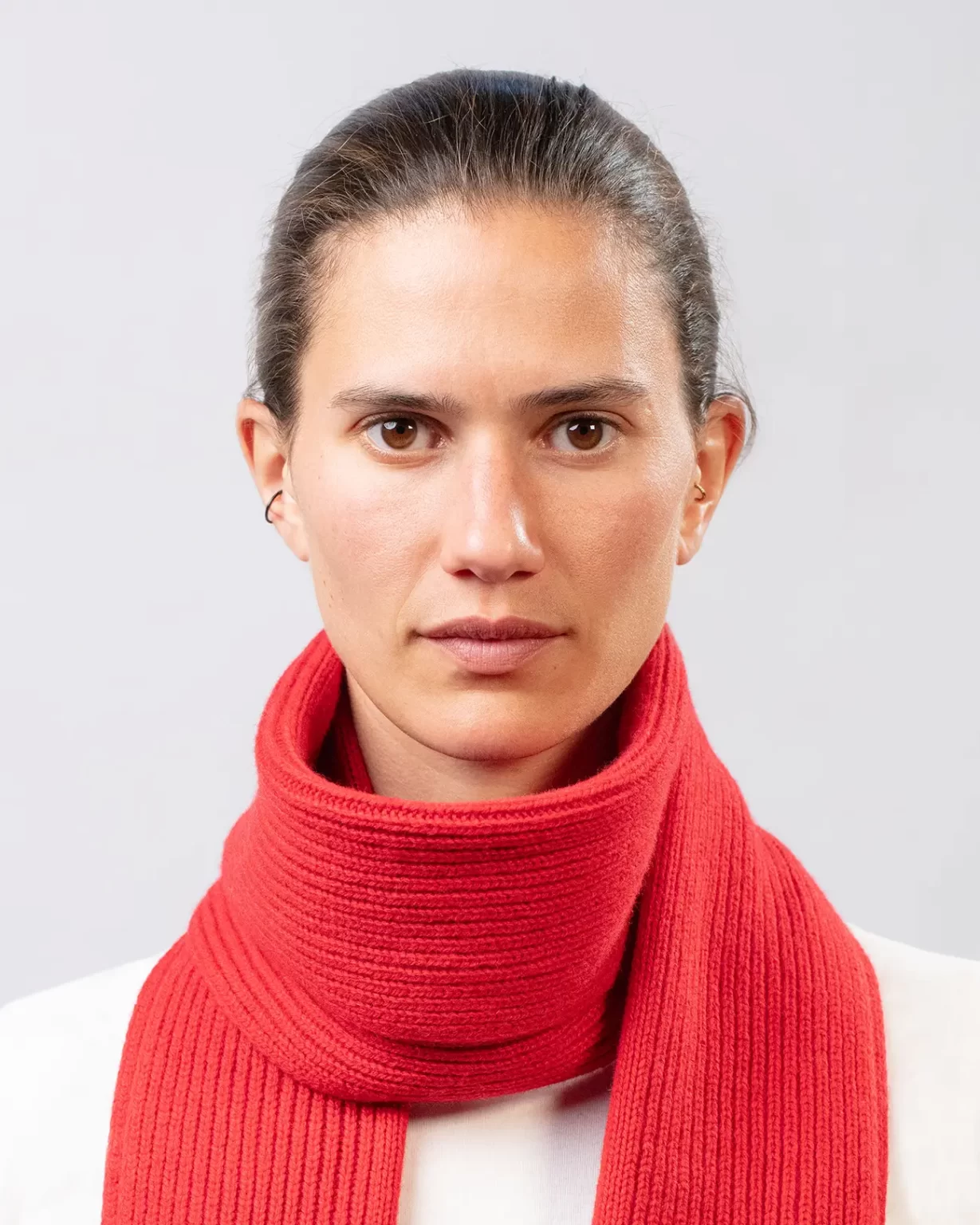 Photographie studio détaillée de l'Echarpe Cachemire Régénéré Rouge, porté par un mannequin Femme. Cette écharpe est fabriqué en France, à partir de Laine et de Cachemire Recyclé, par la marque haut-de-gamme Maison Douillet. Cest un modèle pour Homme et Femme.