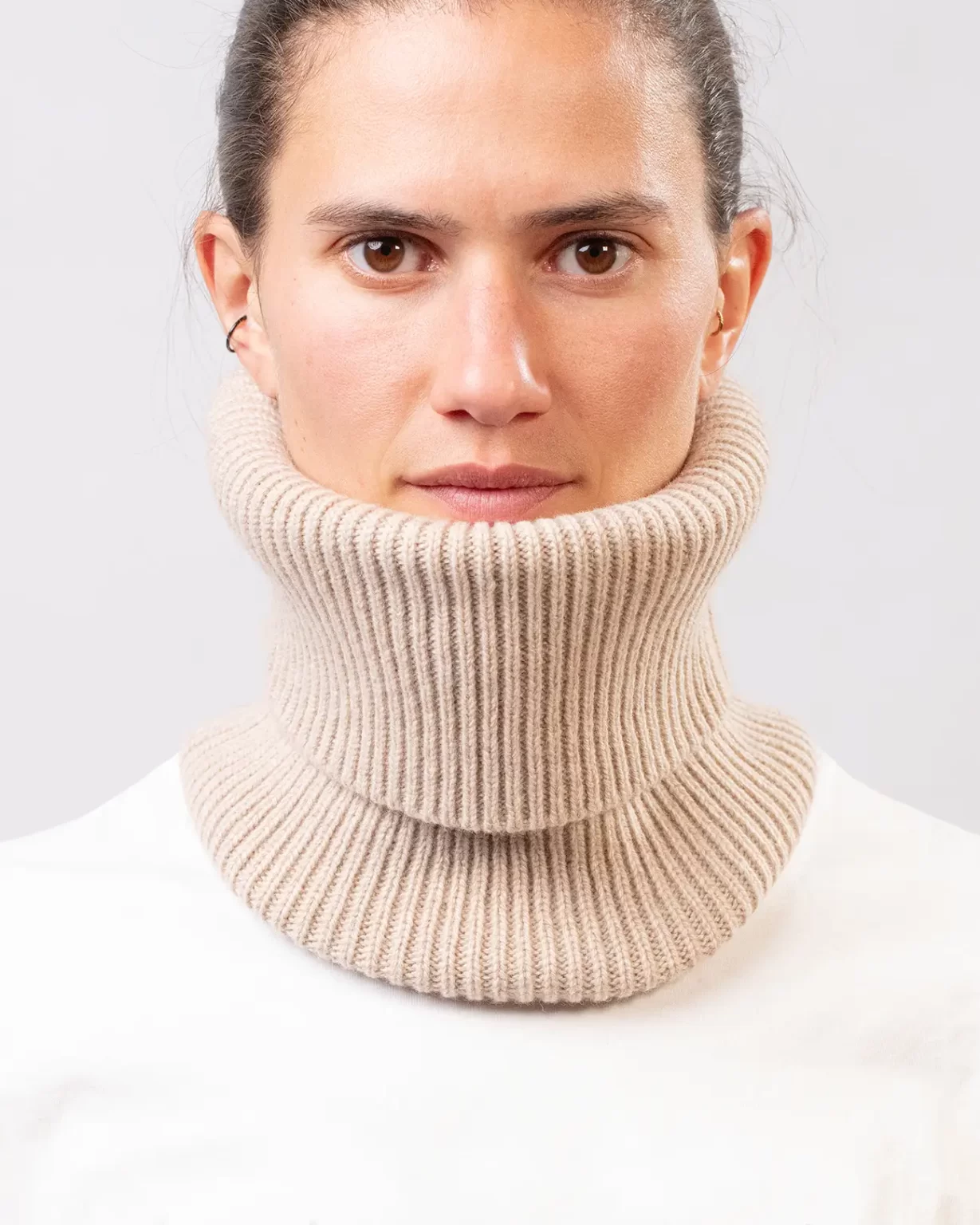 Photographie studio en détail du Tour de Cou Cachemire Régénéré Beige, porté par un mannequin Femme. Ce tour de cou est fabriqué en France, à partir de Laine et de Cachemire Recyclé, par la marque haut-de-gamme Maison Douillet. Cest un modèle pour Homme, Femme et Enfant.