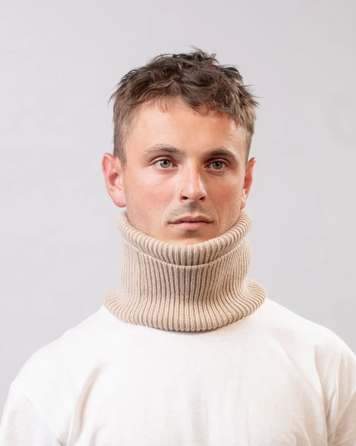 Photographie studio du dos du Tour de Cou Cachemire Régénéré Beige, porté par un mannequin Homme. Ce tour de cou est fabriqué en France, à partir de Laine et de Cachemire Recyclé, par la marque haut-de-gamme Maison Douillet. Cest un modèle pour Homme, Femme et Enfant.