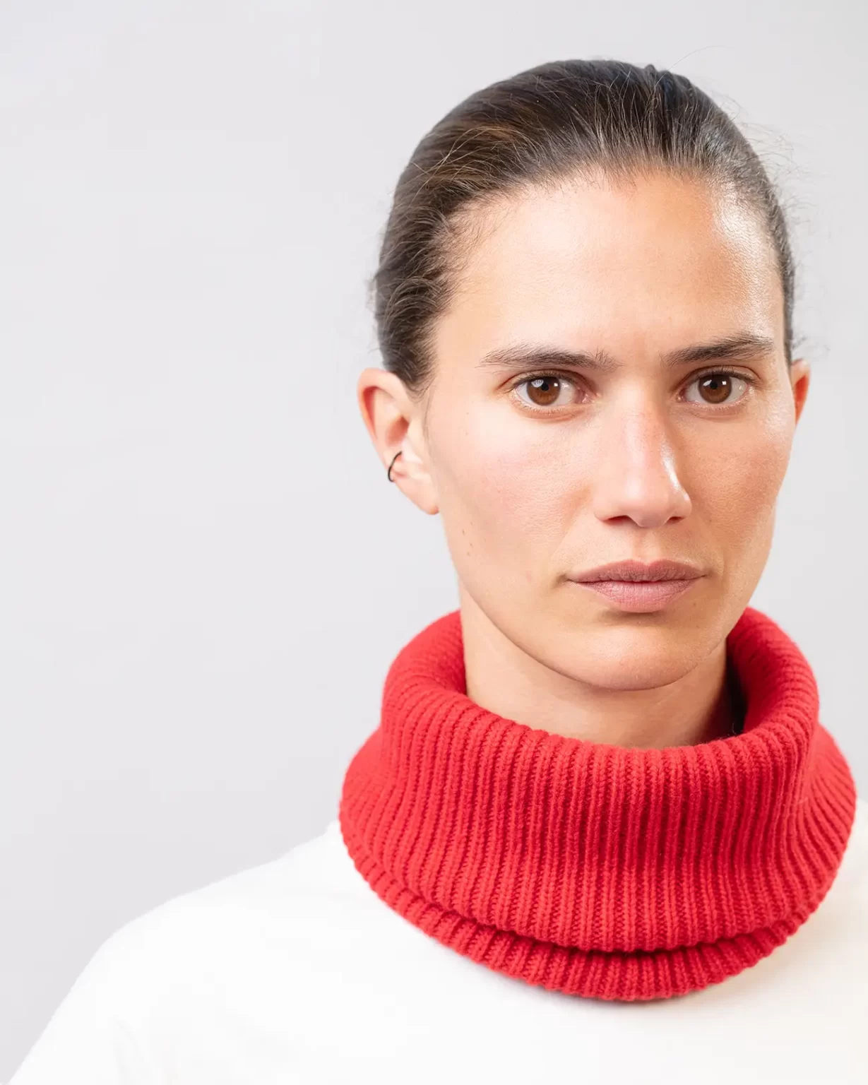 Photographie studio en détail du Tour de Cou Cachemire Régénéré Rouge, porté par un mannequin Femme. Ce tour de cou est fabriqué en France, à partir de Laine et de Cachemire Recyclé, par la marque haut-de-gamme Maison Douillet. Cest un modèle pour Homme, Femme et Enfant.