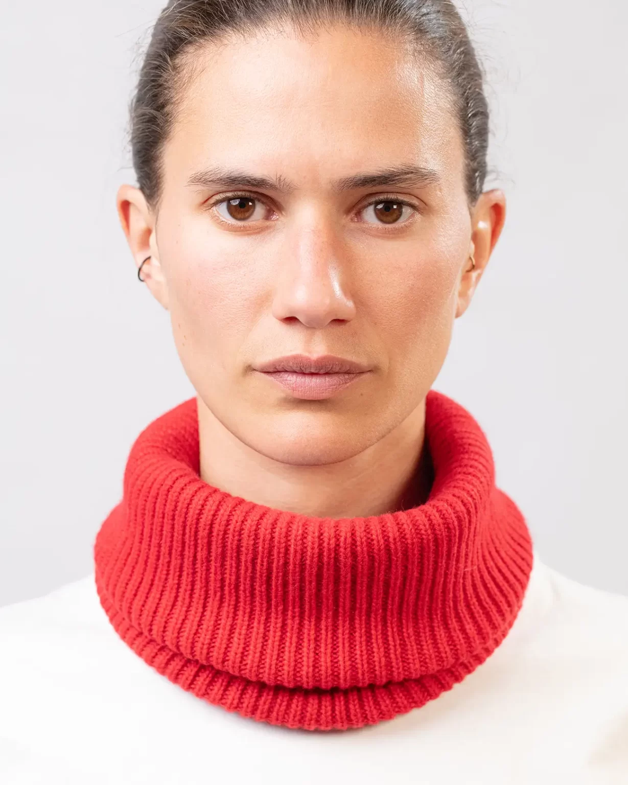 Photographie studio en détail du Tour de Cou Cachemire Régénéré Rouge, porté par un mannequin Femme. Ce tour de cou est fabriqué en France, à partir de Laine et de Cachemire Recyclé, par la marque haut-de-gamme Maison Douillet. Cest un modèle pour Homme, Femme et Enfant.