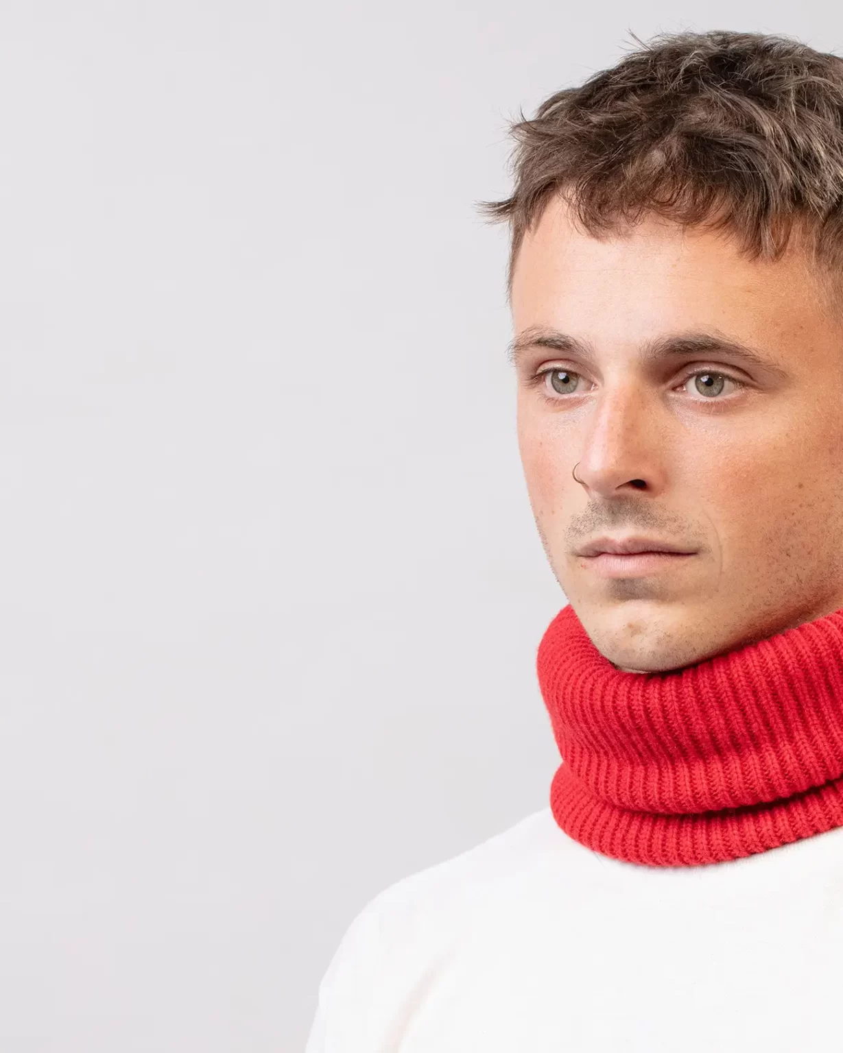 Photographie studio en détail du Tour de Cou Cachemire Régénéré Rouge, porté par un mannequin Homme. Ce tour de cou est fabriqué en France, à partir de Laine et de Cachemire Recyclé, par la marque haut-de-gamme Maison Douillet. Cest un modèle pour Homme, Femme et Enfant.