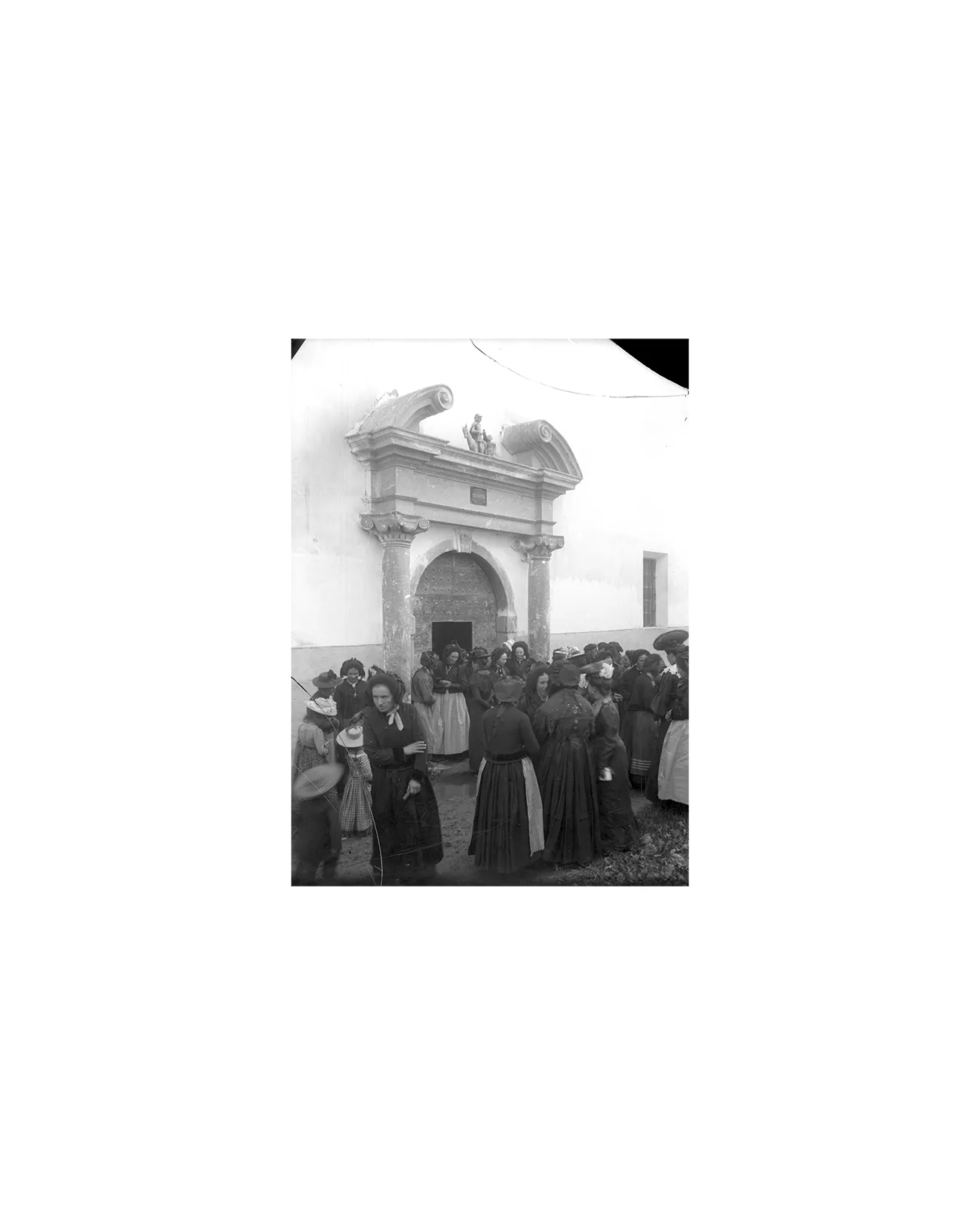 Photographie de la fin du XIXe siècle montrant un groupe de femme à la sortie de la messe, dans le village des Allues (Savoie, France).